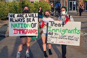 people carrying protest signs against ICE.