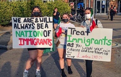 people carrying protest signs against ICE.